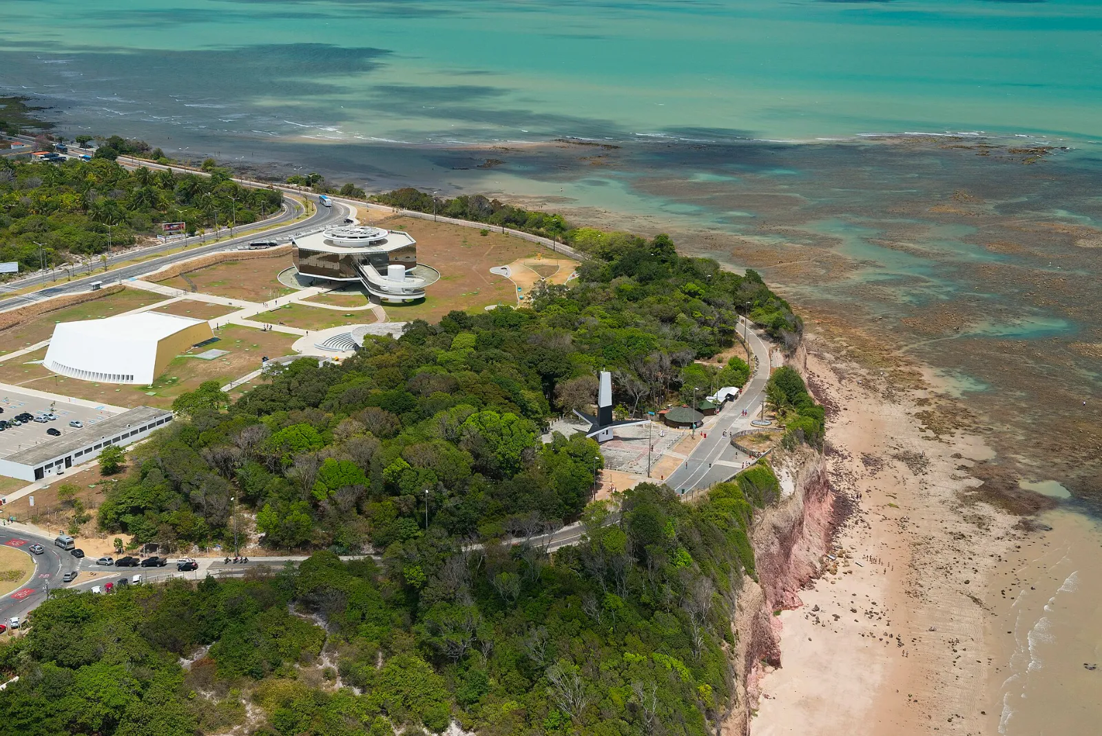 Vista aérea da falésia do Cabo Branco com a Estação Cabo Branco, a área do farol e os recifes no mar ao lado