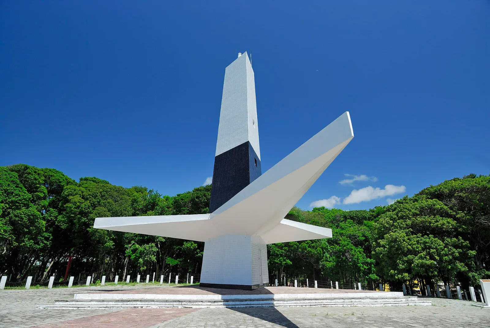 Farol do Cabo Branco com torre triangular e base em forma de agave, sob céu azul