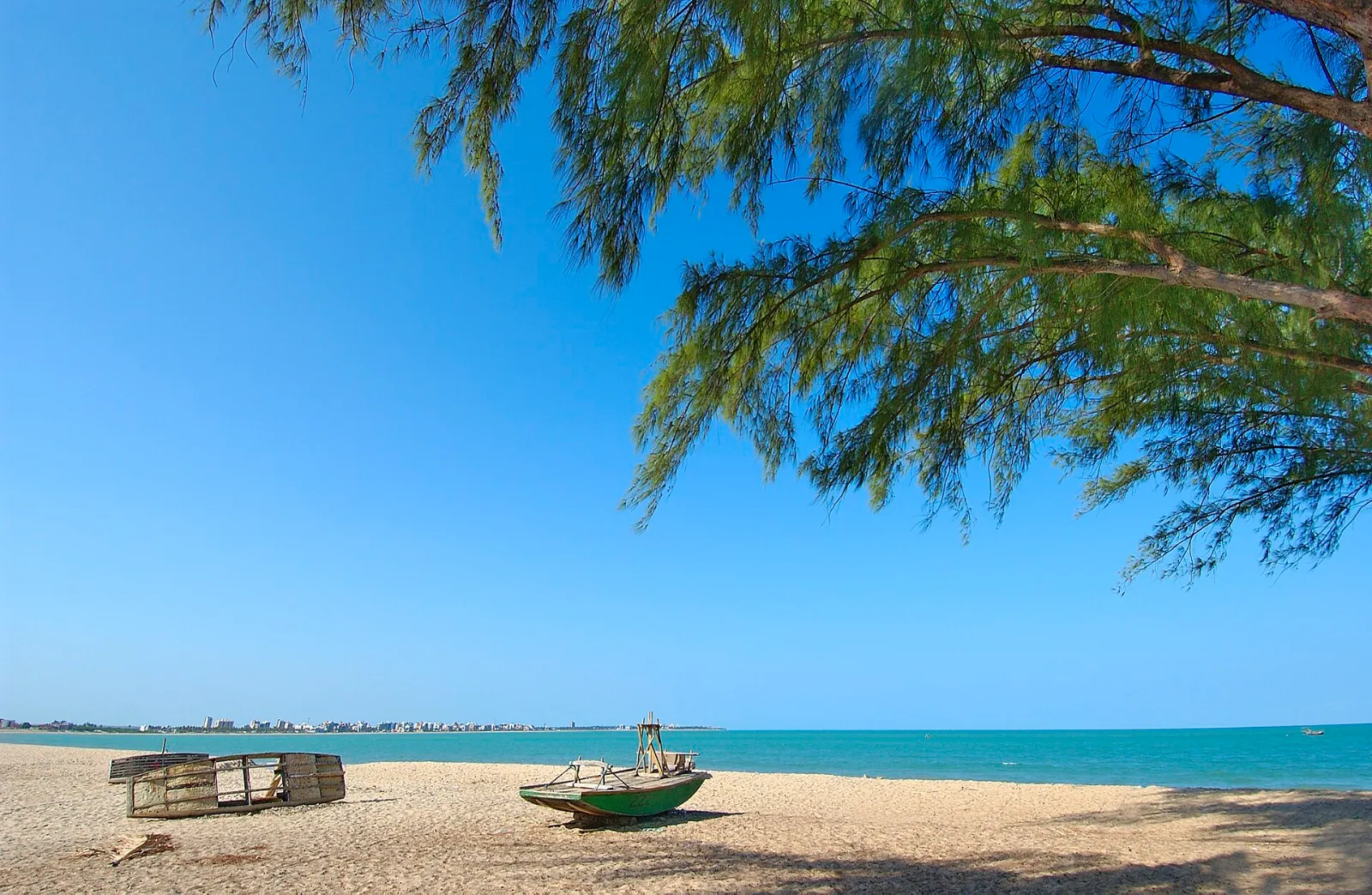 Praia do Bessa com mar azul-esverdeado, areia clara e coqueiros